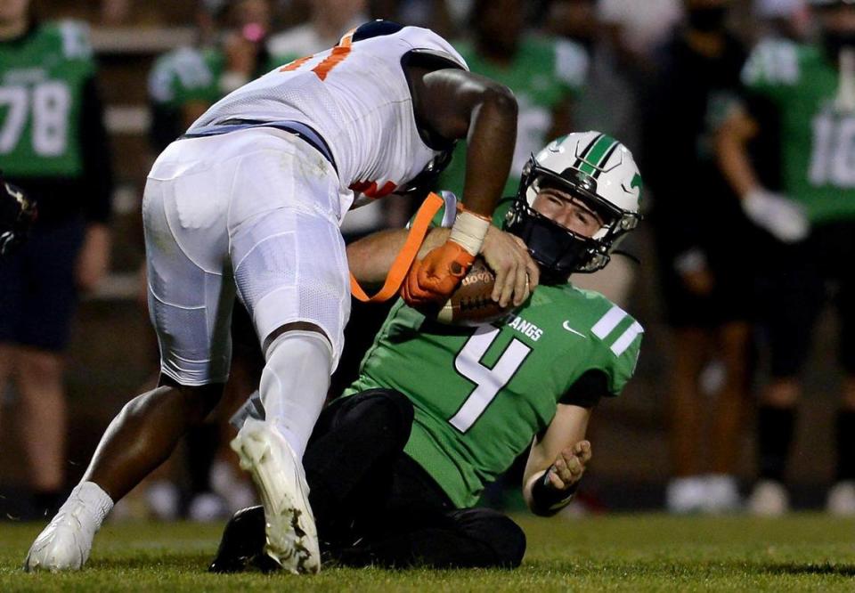 Vance Cougars defensive end James Pearce, left, sacks Myers Park Mustangs quarterback Lucas Lenhoff, right, during second quarter action on Friday, April 30, 2021 at Myers Park High School. The teams are competing in the NCHSAA 4AA state semifinals.