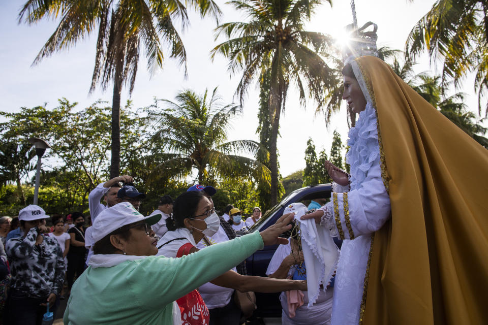 Faithful reach out to touch a statue of the Virgin Mary during an event marking Good Friday at the Metropolitan Cathedral in Managua, Nicaragua, Friday, April 7, 2023. Holy Week commemorates the last week of the earthly life of Jesus, culminating in his crucifixion on Good Friday and his resurrection on Easter Sunday. (AP Photo/Inti Ocon)