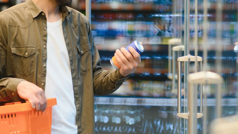Person inspecting store beer can