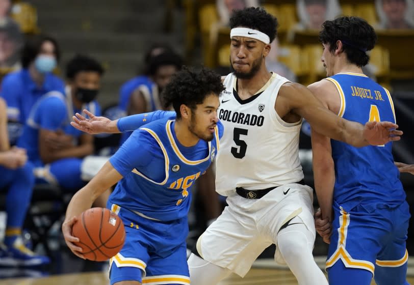 UCLA guard Johnny Juzang is defended by Colorado guard D'Shawn Schwartz during the second half of an NCAA college basketball game Saturday, Feb. 27, 2021, in Boulder, Colo. (AP Photo/David Zalubowski)