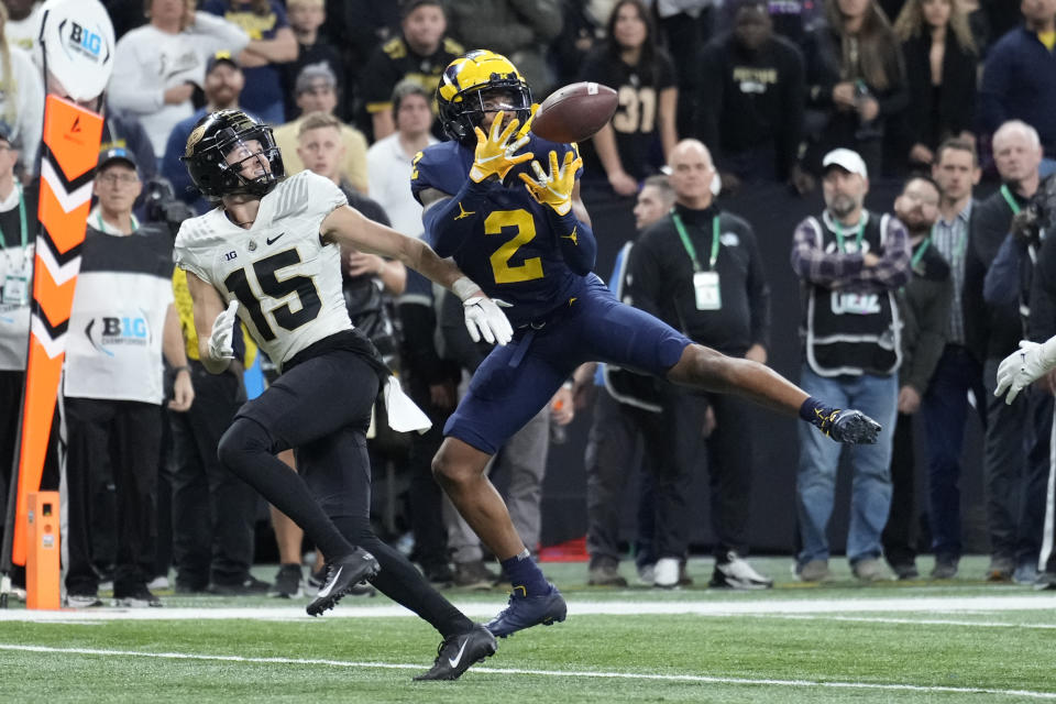 Michigan defensive back Will Johnson (2) intercepts a pass intended for Purdue wide receiver Charlie Jones (15) during the second half of the Big Ten championship NCAA college football game, Saturday, Dec. 3, 2022, in Indianapolis. (AP Photo/AJ Mast)