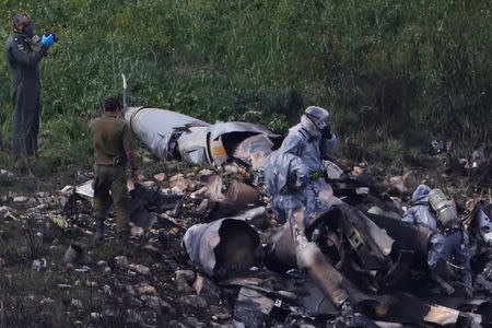 Israeli security forces examine the remains of an F-16 Israeli war plane near the village of Harduf, Israel February 10, 2018. REUTERS/ Ronen Zvulun