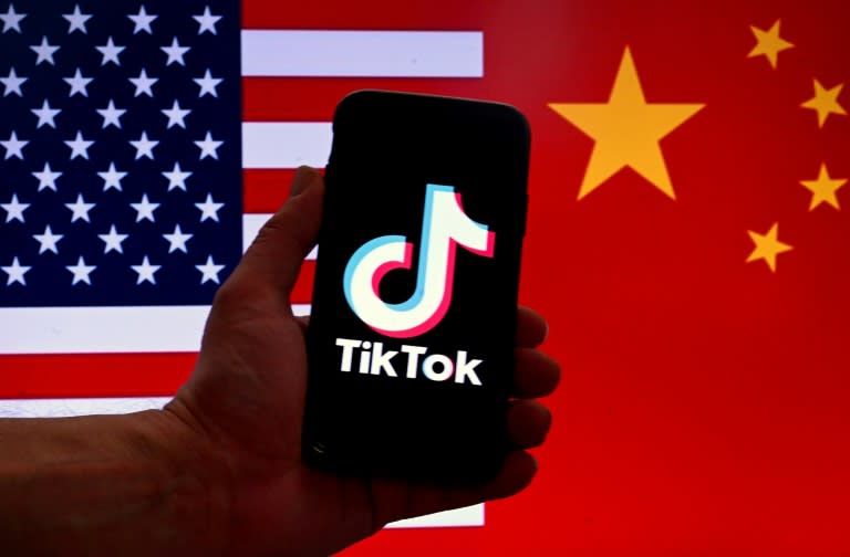 El logotipo de la aplicación de la red social TikTok, fotografaida en un teléfono móvil delante de unas banderas de EEUU (izq.) y China, el 16 de marzo de 2023 en Washington (Olivier Douliery)