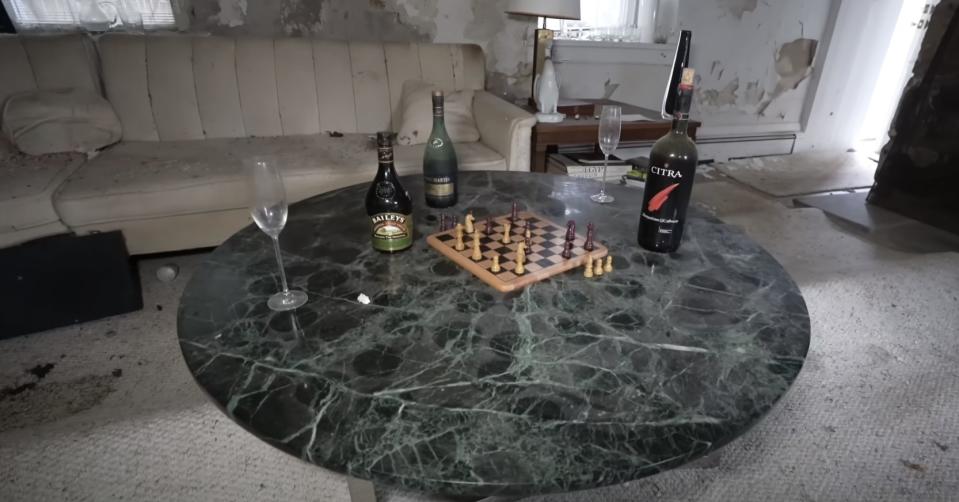 A table with an old chess board and wine bottles