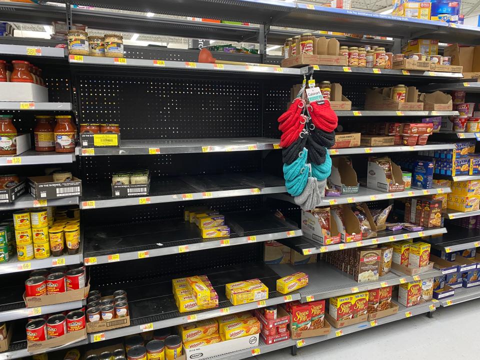 empty shelves with some products in a walmart