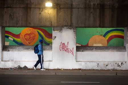 A man walks past concrete barriers installed under an overpass to deter homeless camping in Chicago, December 4, 2014. The angled concrete barriers were installed earlier in the year to prevent the homeless from sleeping between the bridge supports. REUTERS/Andrew Nelles