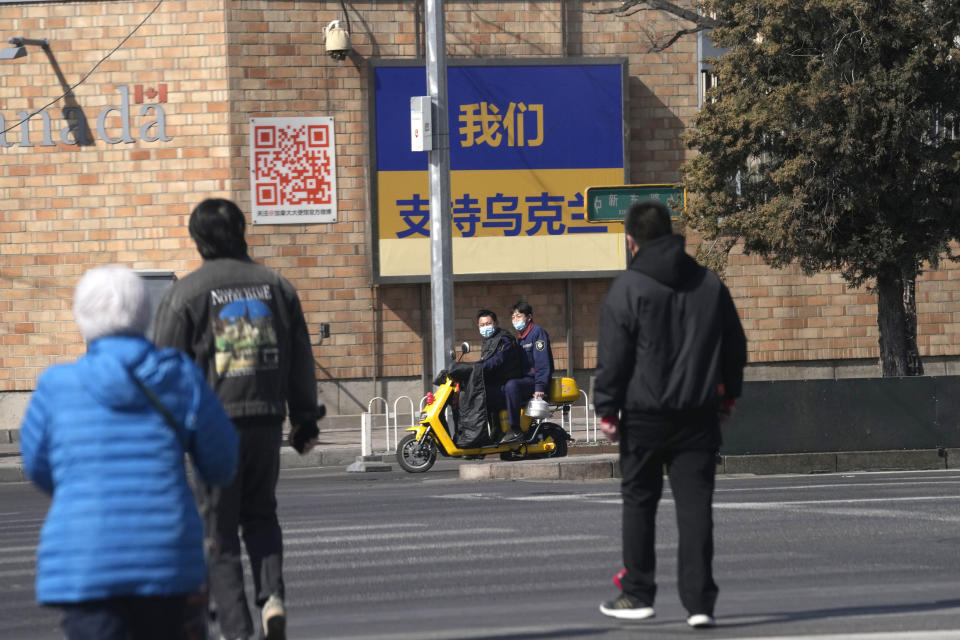 A sign partially covered up after being defaced is seen outside the Canadian Embassy showing the Ukrainian flag with the words "We support Ukraine" on Thursday, March 3, 2022, in Beijing. China on Thursday denounced a report that it asked Russia to delay invading Ukraine until after the Beijing Winter Olympics as "fake news" and a "very despicable" attempt to divert attention and shift blame over the conflict. (AP Photo/Ng Han Guan)