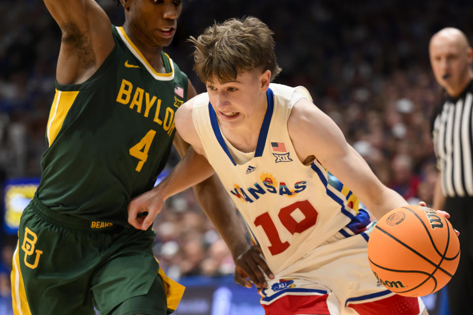 Kansas guard Johnny Furphy (10) drives around Baylor guard Ja'Kobe Walter (4) during the first half of an NCAA college basketball game in Lawrence, Kan., Saturday, Feb. 10, 2024. (AP Photo/Reed Hoffmann)