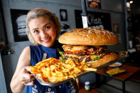 Una mujer levanta la que, según el restaurante de Bangkok Chris Steaks & Burgers, es la hamburguesa más grande de Tailandia con un peso de 6 kilos. Fotografía del 11 de octubre. (Foto: Jiraporn Kuhakan / Reuters).