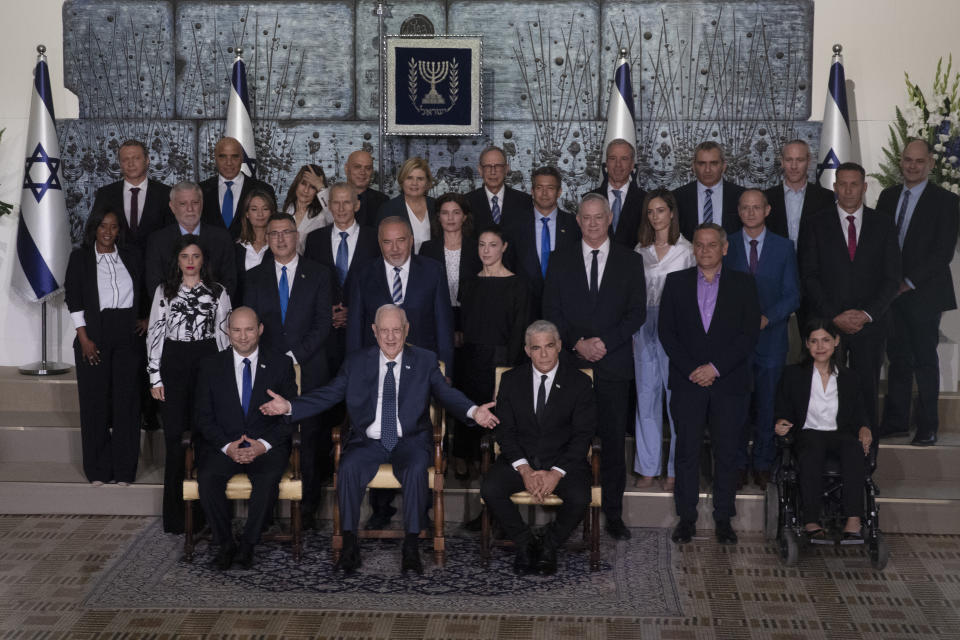 Israeli Prime Minister Naftali Bennett, seated left, President Reuven Rivlin, seated center, and Alternate Prime Minister and Minister of Foreign Affairs Yair Lapid seated right, pose for a group photo with the ministers of the new government at the President's residence in Jerusalem, Monday, June 14, 2021. (AP Photo/Maya Alleruzzo)