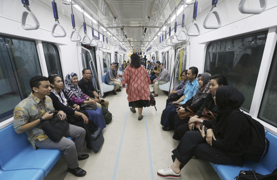 In this Feb. 21, 2019, photo, people ride on a Mass Rapid Transit (MRT) during a trial run in Jakarta, Indonesia. Commuting in the gridlocked Indonesian capital will for some involve less frustration, sweat and fumes when its first subway line opens later this month. The 10-mile system running south from Jakarta's downtown is the first phase of a development that if fully realized will plant a cross-shaped network of stations in the teeming city of 30 million people.(AP Photo/Achmad Ibrahim)
