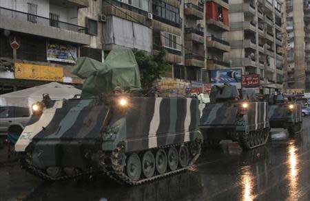 Lebanese army soldiers are seen on their military vehicles as they are deployed on the streets of Tripoli, northern Lebanon, December 3, 2013. REUTERS/Stringer