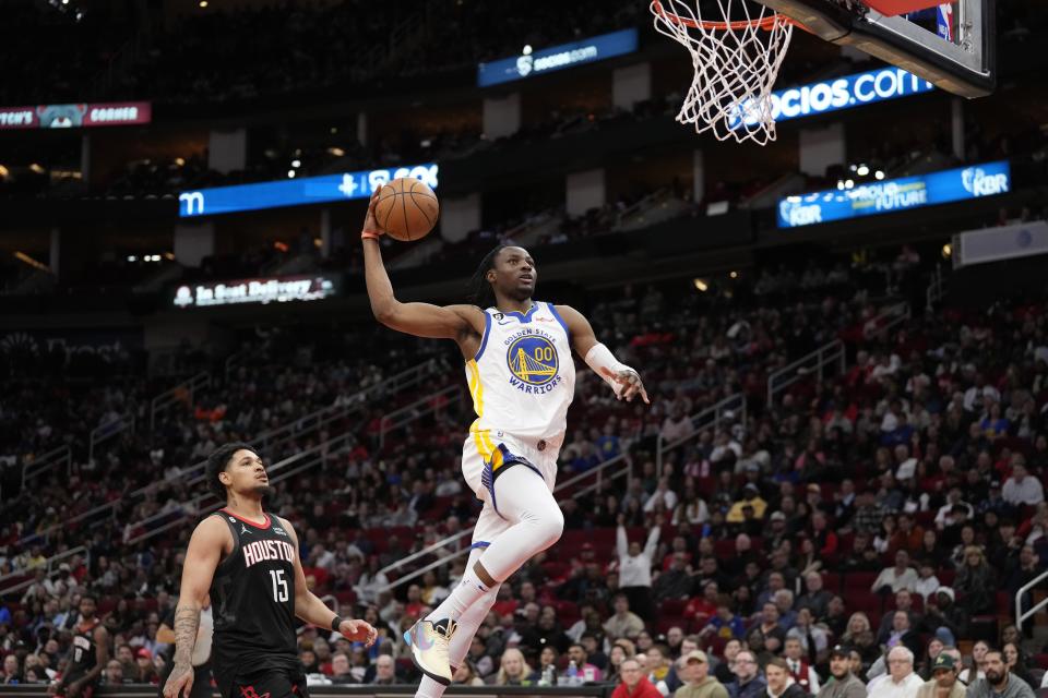 Golden State Warriors' Jonathan Kuminga (00) goes up for a dunk as Houston Rockets' Daishen Nix (15) watches during the second half of an NBA basketball game Monday, March 20, 2023, in Houston. The Warriors won 121-108. (AP Photo/David J. Phillip)