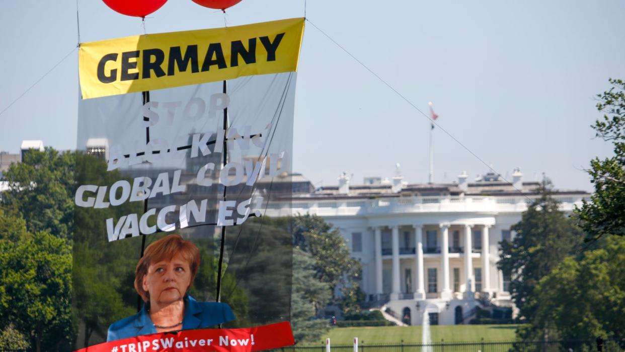 Ein Transparent vor dem Weißen Haus fordert Bundeskanzlerin Merkel dazu auf, ihre Ablehnung einer Sonderaussetzung für Impf-Patente aufzugeben.