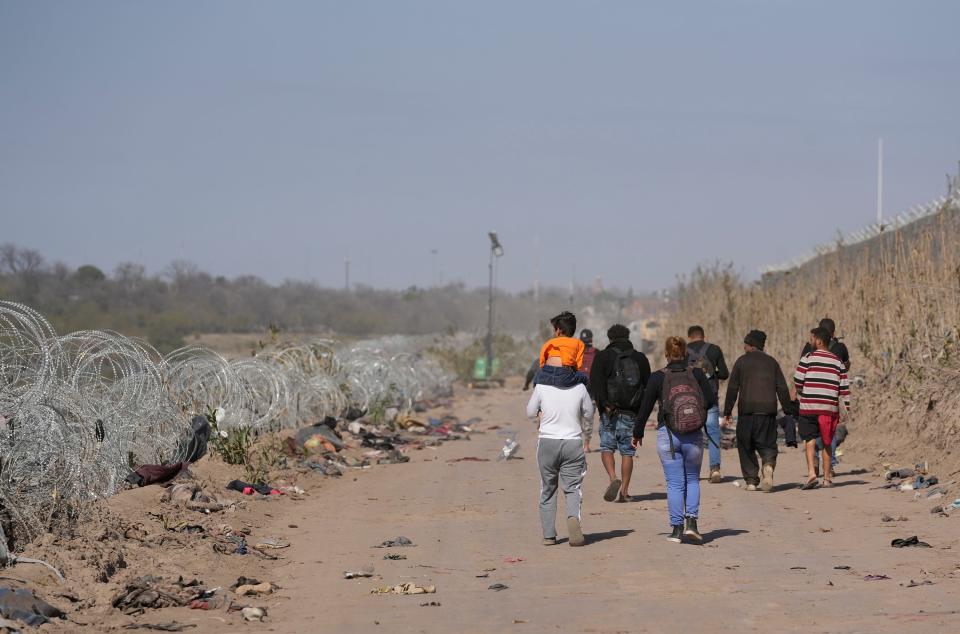 A group of migrants from Venezuela walk along the banks of the Rio Grande to surrender to U.S. Border Patrol after they entered Texas at Eagle Pass on Monday January 8, 2024.