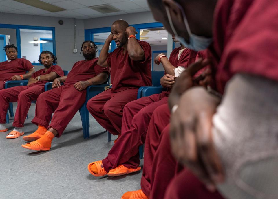 Calvin Clark, center, talks about how he does fades while cutting hair while sitting in with a small group of fellow incarcerated men as part of the I.G.N.I.T.E. (Inmate Growth Naturally and Intentionally Through Education) program held in an activities room of the Genesee County Jail in Flint on Thursday, Jan. 4, 2024. Clark, who had been cutting hair for 10 years before becoming incarcerated, talked about the opportunity to cut the hair of recording artist Jelly Roll during his recent visit to the jail.