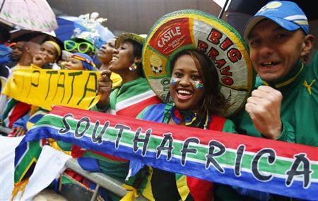 People sing and dance in the rain while waiting for the start of the official memorial service for late South African President Nelson Mandela at the First National Bank soccer stadium, also know as Soccer City, in Johannesburg December 10, 2013. REUTERS/Kai Pfaffenbach