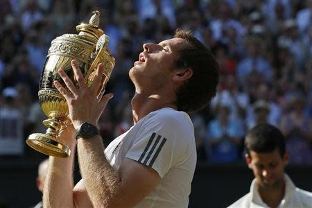 Andy Murray of Britain holds the winners trophy after defeating Novak Djokovic of Serbia in their men's singles final tennis match at the Wimbledon Tennis Championships, in London July 7, 2013. REUTERS/Stefan Wermuth