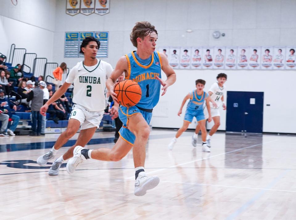 Monache's Ty Baxter drives past Dinuba's Joseph Lopez during The 72nd annual Polly Wilhelmsen Invitational Basketball Tournament first-round game.