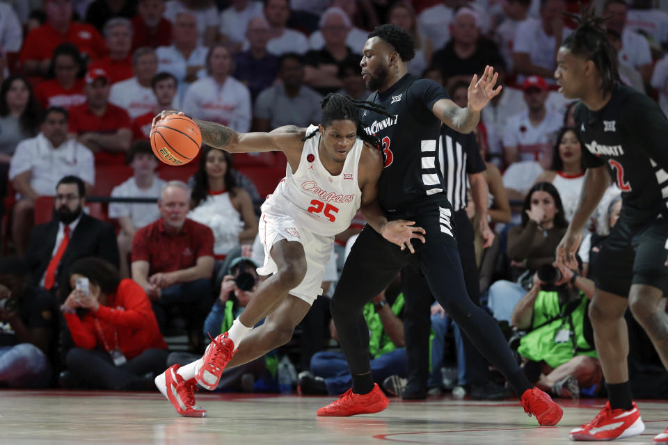 Houston forward Joseph Tugler (25) drives around Cincinnati forward Jamille Reynolds, right, during the first half of an NCAA college basketball game Tuesday, Feb. 27, 2024, in Houston. (AP Photo/Michael Wyke)