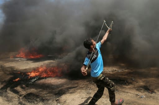 A Palestinian man uses a slingshot during clashes with Israeli forces along the border with the Gaza Strip on May 14, 2018