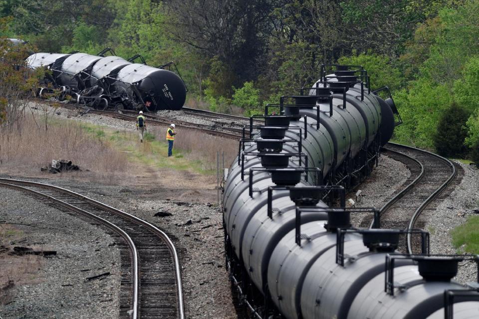 Workers inspect the scene after several CSX tanker cars carrying crude oil derailed and caught fire along the James River in Lynchburg, Va., Wednesday, April 30, 2014. (AP Photo/News & Daily Advance, Parker Michels-Boyce)