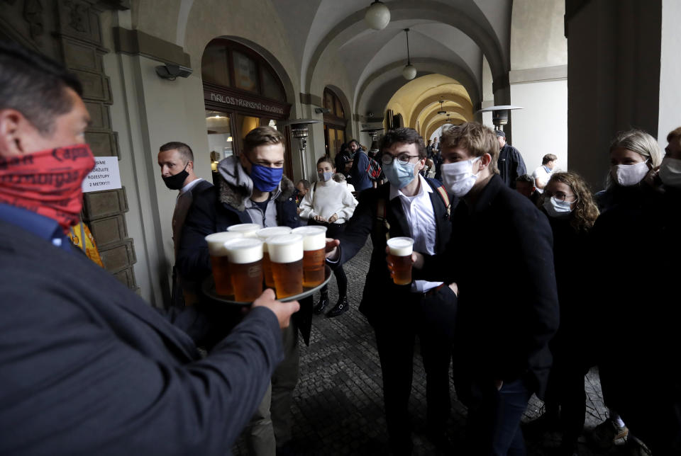 FILE - In this file photo people line up for a beer at a restaurant terrace in Prague, Czech Republic, Monday, May 11, 2020. (AP Photo/Petr David Josek, File)