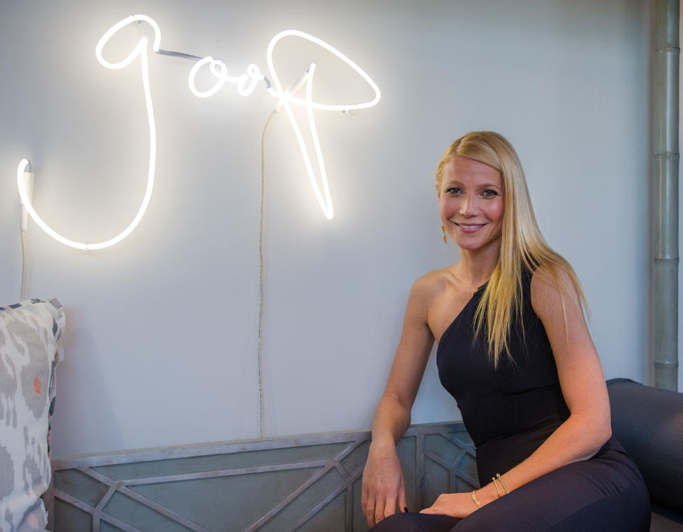 Gwyneth Paltrow poses in front of neon goop sign