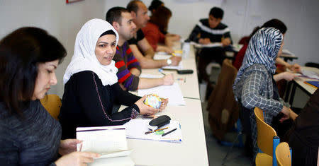 Migrants attend a lesson at the "institute for intercultural communication" in Berlin, Germany, April 13, 2016. REUTERS/Hannibal Hanschke