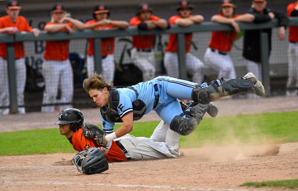 Franklin senior catcher Joe Tirrell leaps into the air as he tags out a Taunton player at home plate during the Division 1 state championship baseball game at LeLacheur Park in Lowell on Saturday, June 18, 2022. Taunton beat Franklin, 2-1, to earn the state championship title.