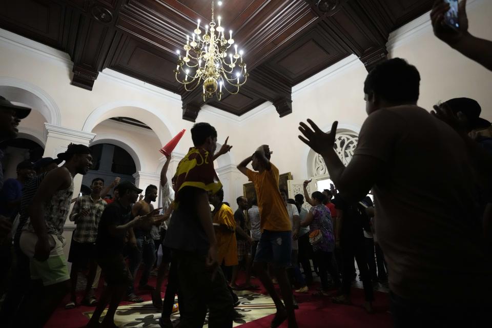 Protesters sing and dance after storming in at the Sri Lankan president official residence, in Colombo, Sri Lanka , Saturday, July, 9, 2022. Protesters have broken into the Sri Lankan prime minister's private residence and set it on fire, hours after he said he would resign when a new government is formed over a worsening economic crisis. It was the biggest day of demonstrations that also saw crowds storming the president's home and office. (AP Photo/ Eranga Jayawardena)