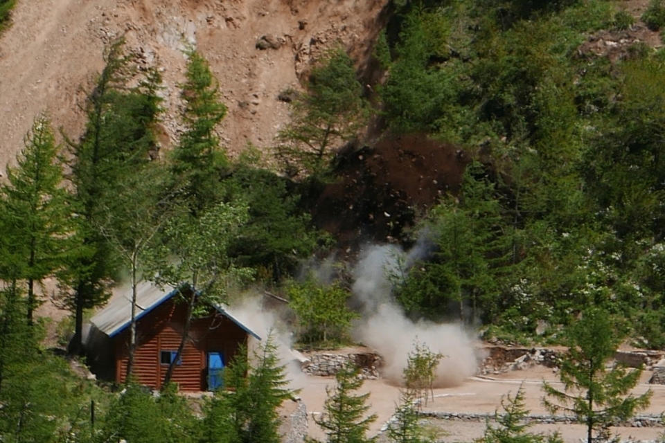 Smoke and debris go up in the air as the entrance to the north tunnel at North Korea's nuclear test site is blown up during a media tour of dismantling the test site at Punggye-ri, North Hamgyong Province, North Korea, Thursday, May 24, 2018. (APTN via AP)