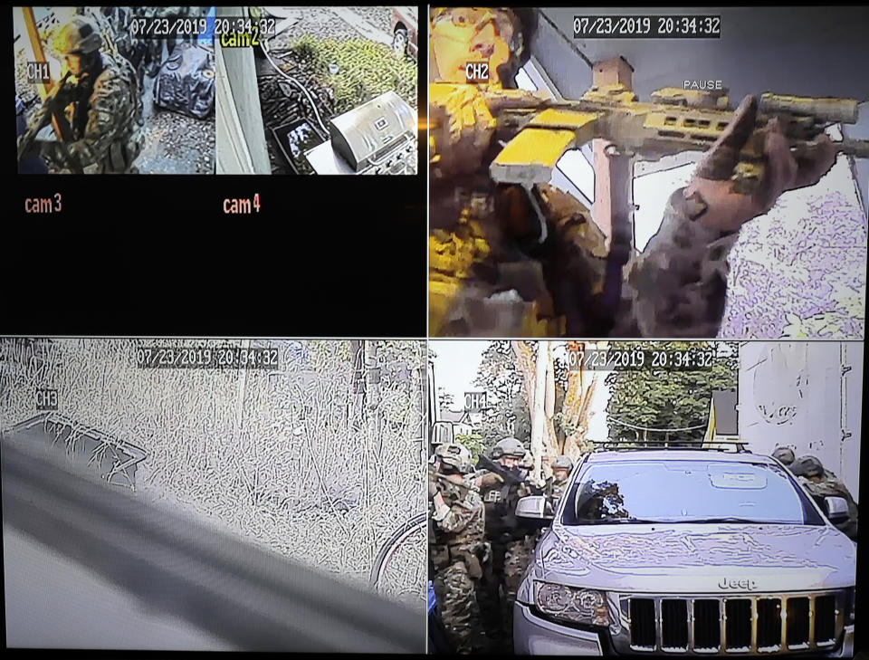 In this image made from a Monday, July 29, 2019, security camera video provided by a neighbor who has requested not to be identified, federal agents conduct a raid on the home of Paige A. Thompson in Seattle. Thompson is accused of accessing the personal information of millions of Capital One credit card holders or credit card applicants in the U.S. and Canada. The time and date stamp on the image is inaccurate, as the raid took place on Monday, July 29, 2019. (Courtesy Photo via AP)