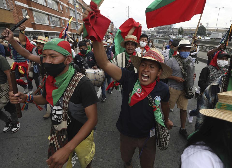 Indigenous people shout slogans against the government during a march in Bogota, Colombia, Monday, Oct. 19, 2020. The leaders of the indigenous communities say they are mobilizing to reject massacres, assassinations of social leaders, criminalization of social protest, to defend their territory, democracy and peace, and plan to stay in the capital for a nationwide protest and strike on Oct. 21. (AP Photo/Fernando Vergara)