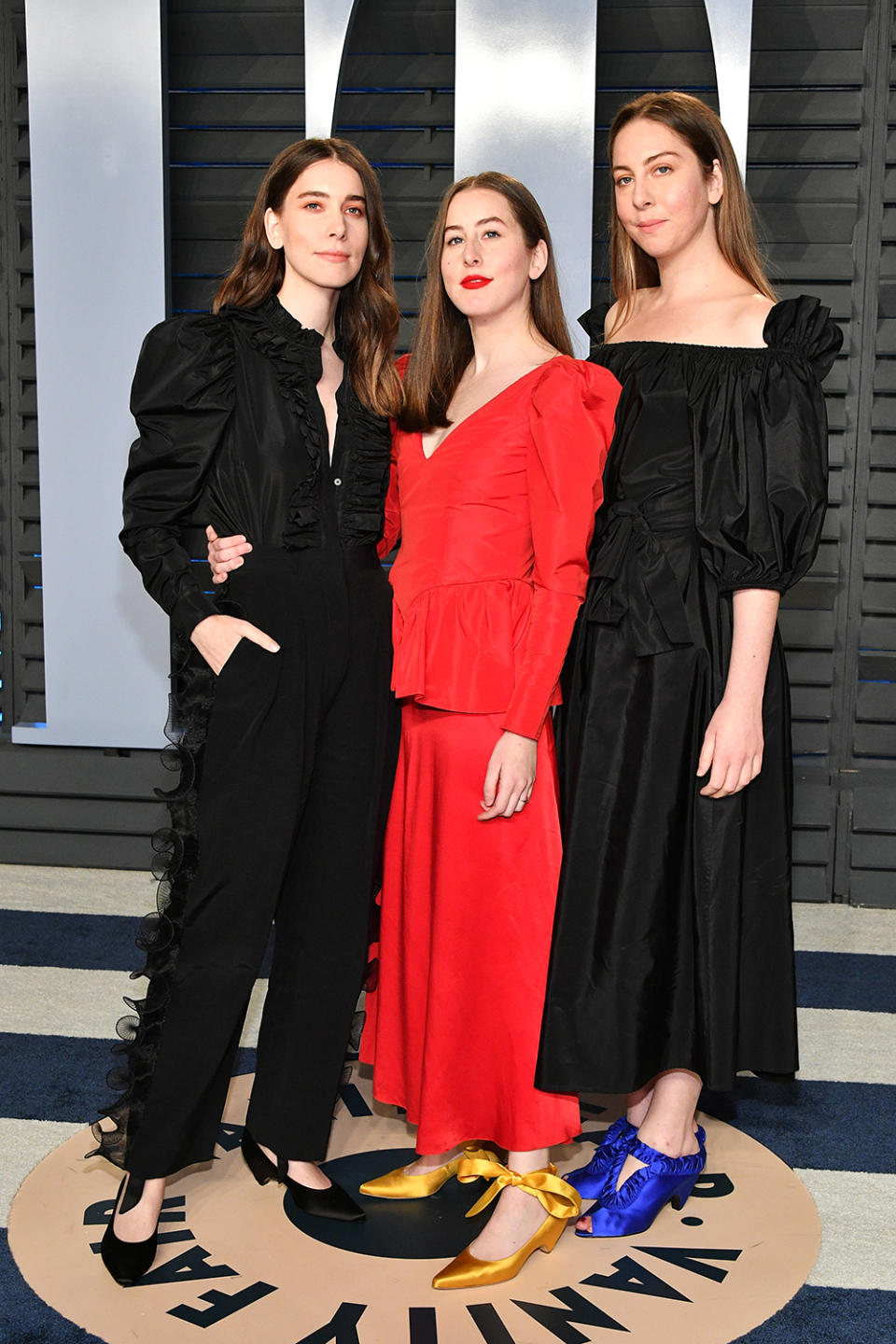<p>Sisters Danielle, Alana, and Este Haim went for monochrome looks, accented with ribbon-tied satin shoes. (Photo: Dia Dipasupil/Getty Images) </p>