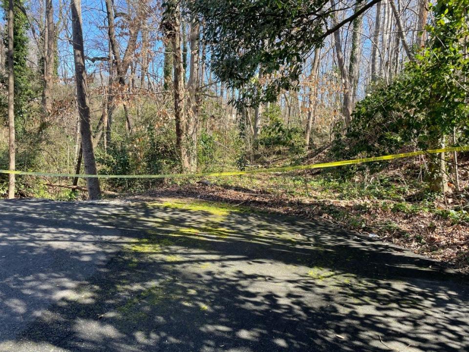 Police tape was hanging across a wooded area at the Village Green Townhomes after a deadly shooting occurred early Saturday.