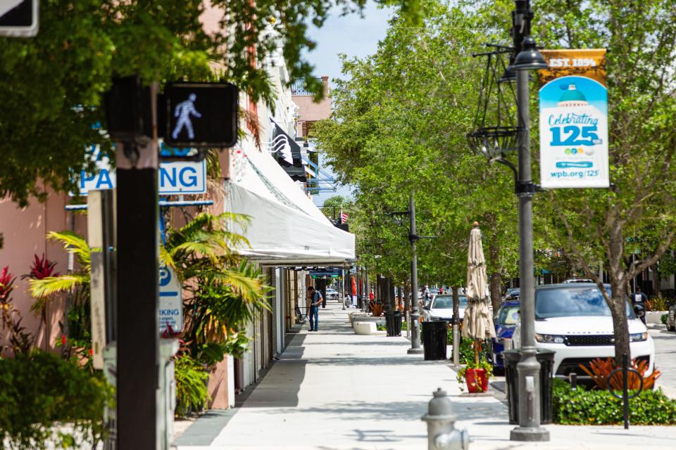 A lone person stands on the sidewalk of Clematis Street in West Palm Beach amid the spring 2020 business shutdown due to the coronavirus outbreak.