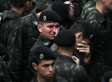 Brazilian soldiers react during a memorial ceremony with the coffins of the victims of the plane crash in Colombia, in the Arena Conda stadium in Chapeco, Brazil, December 3, 2016. REUTERS/Ricardo Moraes