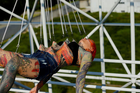 Kaitlin, 28, from the United States is suspended from hooks pierced through her skin by the professional body artist Dino Helvida in Zagreb, Croatia June 7, 2016. REUTERS/Antonio Bronic