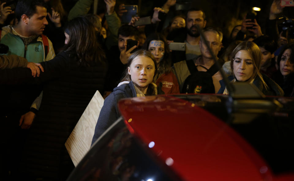 Climate activist Greta Thunberg, centre, leaves the protest in Madrid, Friday Dec. 6, 2019. Thunberg arrived in Madrid Friday to join thousands of other young people in a march to demand world leaders take real action against climate change. (AP Photo/Andrea Comas)