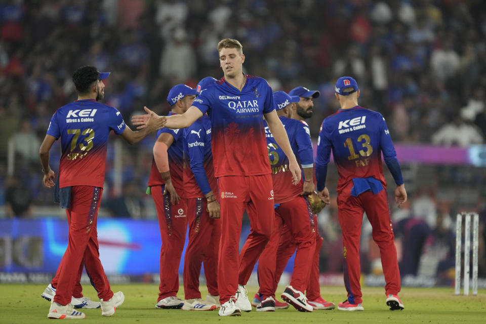 Royal Challengers Bengaluru's Cameron Green, center, celebrates with teammates after the dismissal of Rajasthan Royals' Yashasvi Jaiswal during the Indian Premier League eliminator cricket match between Royal Challengers Bengaluru and Rajasthan Royals in Ahmedabad, India, Wednesday, May 22, 2024. (AP Photo/Ajit Solanki)