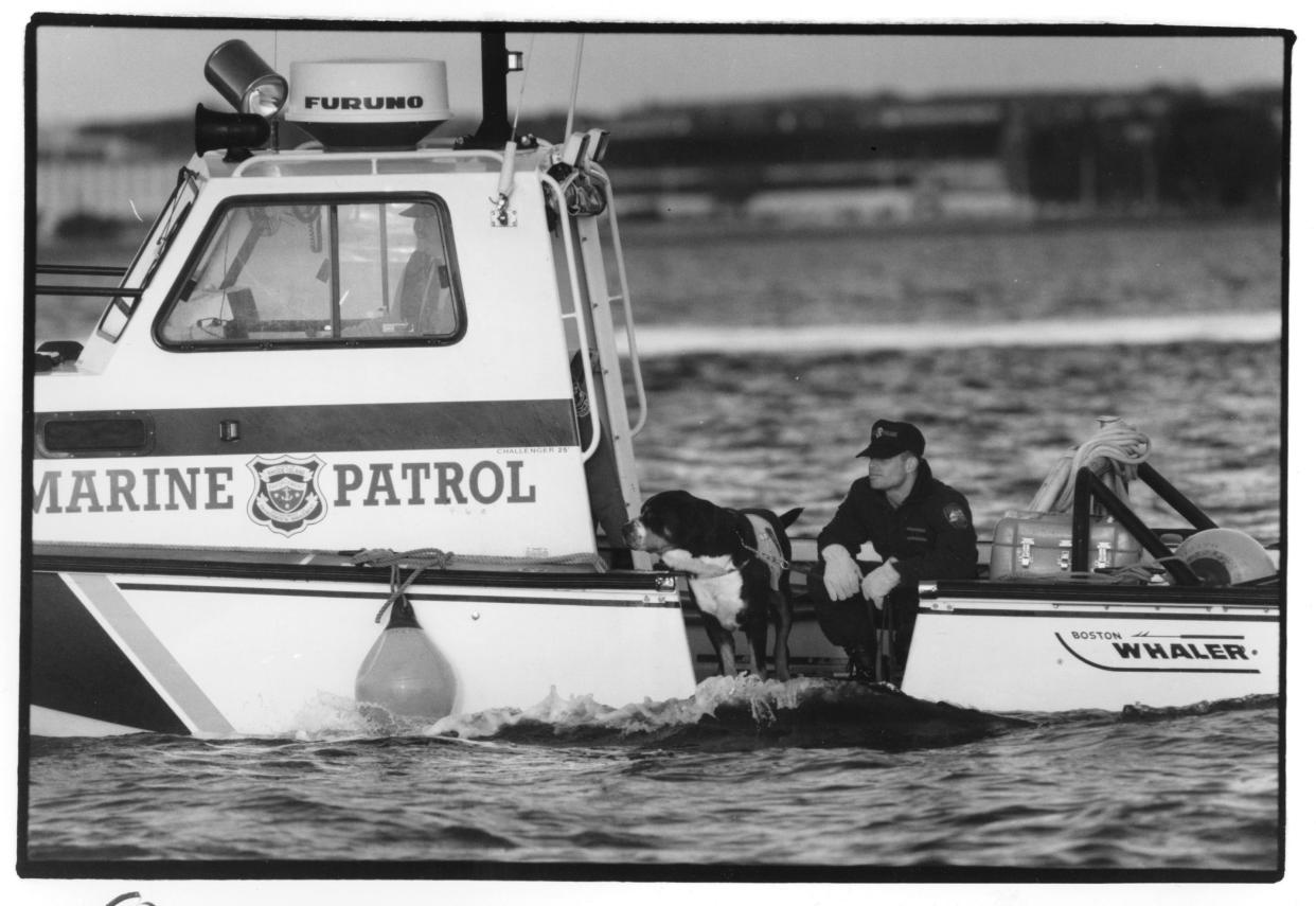 In this November 1993 file photo, Rhode Island State Police Trooper Matthew Zarrella and K9 Hannibal take part in a search of the waters beneath the Pell Bridge, where convicted murderer Adam Emery and his wife, Elena, were thought to have jumped into Narragansett Bay.