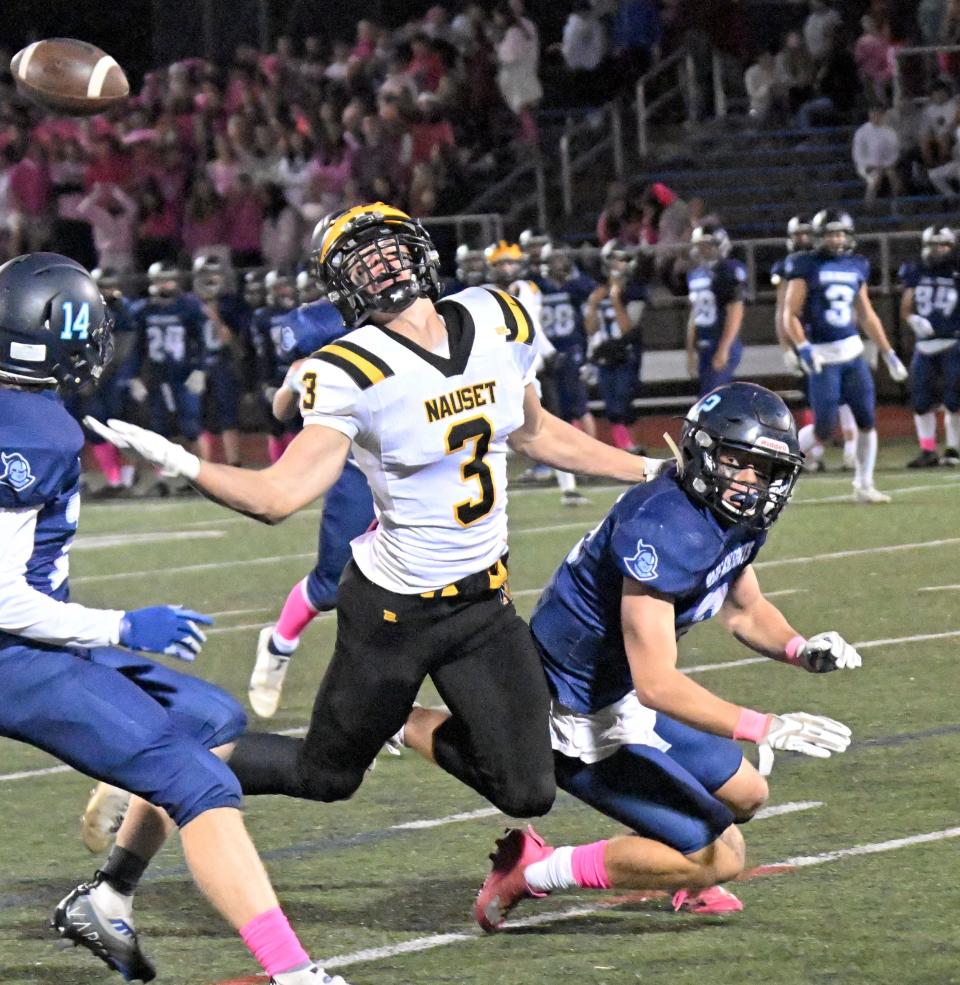 SANDWICH  10/21/22 Dillon White of Nauset tips a pass up to his teammate Kieran Handville surrounded by Lincoln Shinn (14) and Brady Carroll of Sandwich.