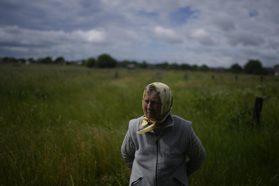 Tetiana Kutsenko stands outside her home that was occupied by Russian soldiers in Makariv, on the outskirts of Kyiv, Ukraine, Tuesday, June 14, 2022. When Kutsenko got back her home that Russian troops had occupied, she found bloodstains and an apparent bullet hole on the bathroom floor and tripwires in her back yard. (AP Photo/Natacha Pisarenko)