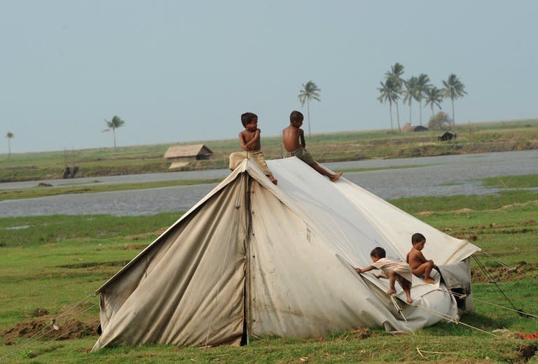 Rohingya children play on a relief tent at a camp for Internally Displaced People on the outskirts of Sittwe on May 18, 2013. Communal unrest last year in the western state of Rakhine left about 200 people dead and up to 140,000 displaced, mainly Rohingyas, minority Muslims who are rejected by many in Myanmar