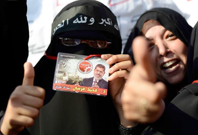 Female supporters of Egyptian President Mohamed Morsi hold up his image during a rally outside Cairo University on June 2, 2013. Morsi told Egyptians that he had been freely elected little more than a year ago and intended to continue to carry out his duties despite mass protests demanding his resignation