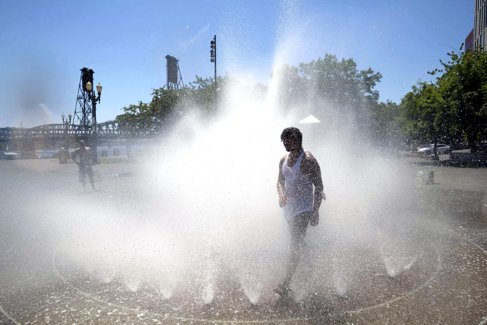 Harrison Valetski cools off in Salmon Street Springs in downtown Portland, Ore., on Monday, where temperatures reached an all-time high of 116 degrees Fahrenheit. (Alex Milan Tracy / Sipa USA via AP)