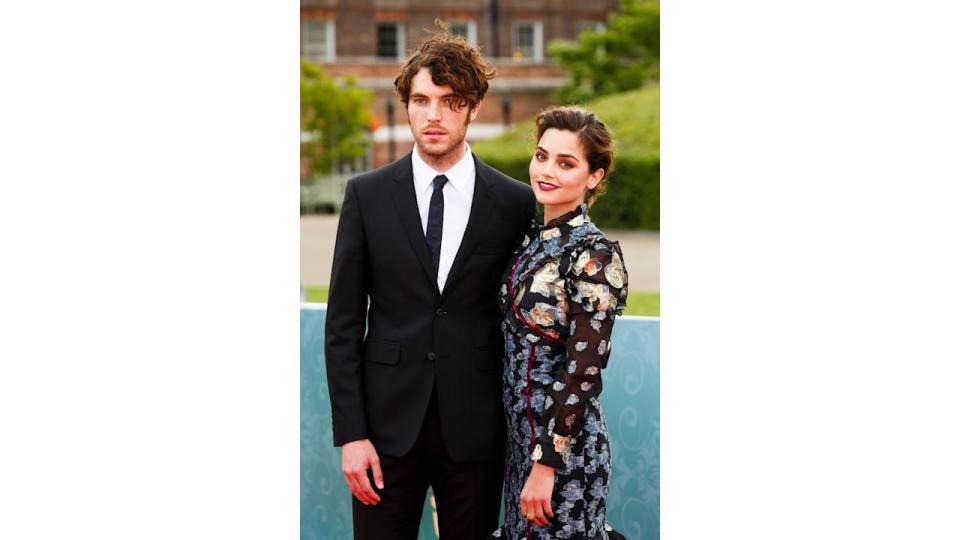 Tom Hughes in a black suit with Jenna Coleman