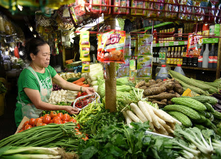 A woman arranges vegetable in a market stall in Edsa Kamias in Quezon City, metro Manila, May 23, 2018. REUTERS/Dondi Tawatao