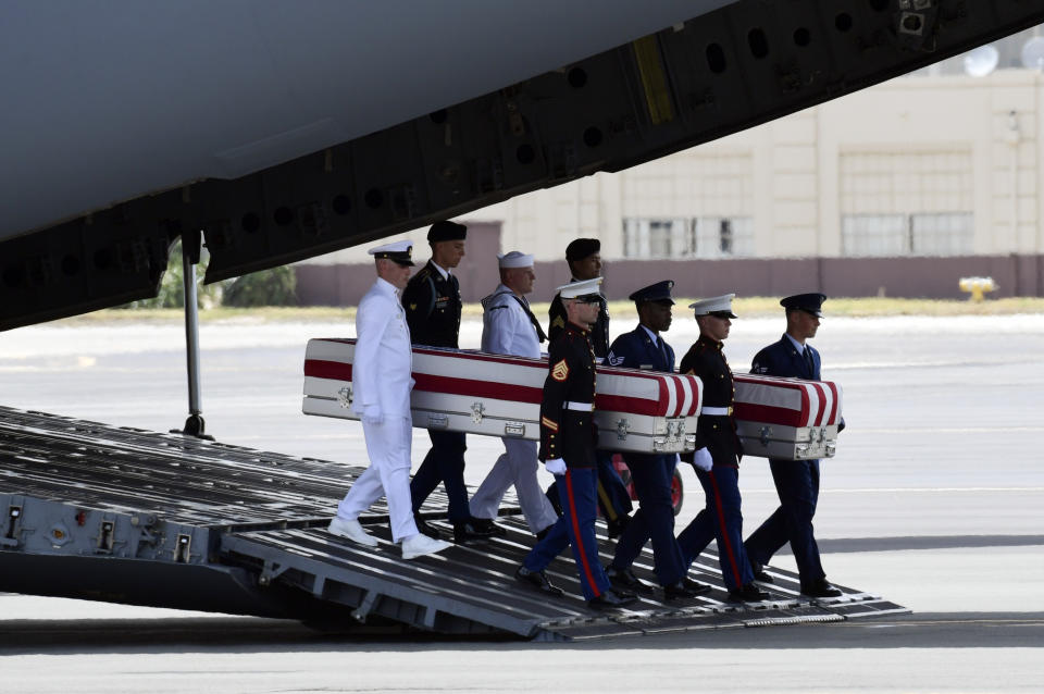 Military members carry transfer cases from a C-17 at a ceremony marking the arrival of the remains believed to be of American service members who fell in the Korean War at Joint Base Pearl Harbor-Hickam in Hawaii, Wednesday, Aug. 1, 2018. North Korea handed over the remains last week. (AP Photo/Susan Walsh)